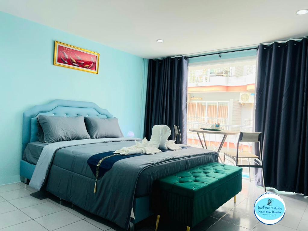 华欣Ocean Blue Huahin Guesthouse的蓝色卧室,配有床和桌子