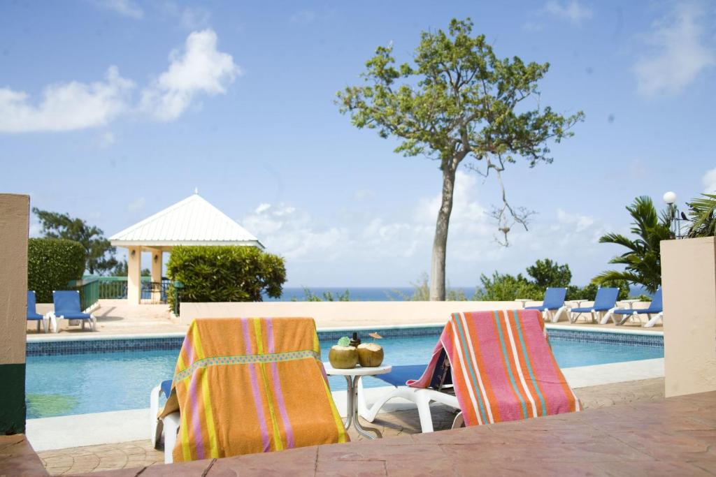 拉纳韦贝加的夫Spa酒店的游泳池畔的两把椅子和一张桌子