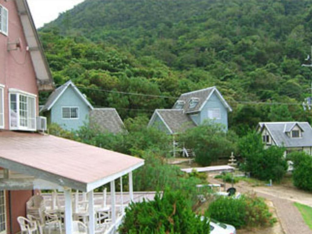 京丹后市レンタルコテージサントロペ的山前的一群房子