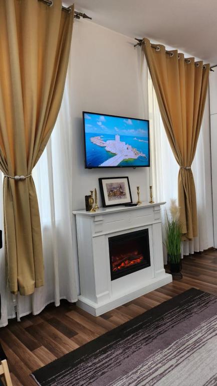 锡比乌Piazza Grande Apartment的客厅设有壁炉和平面电视。
