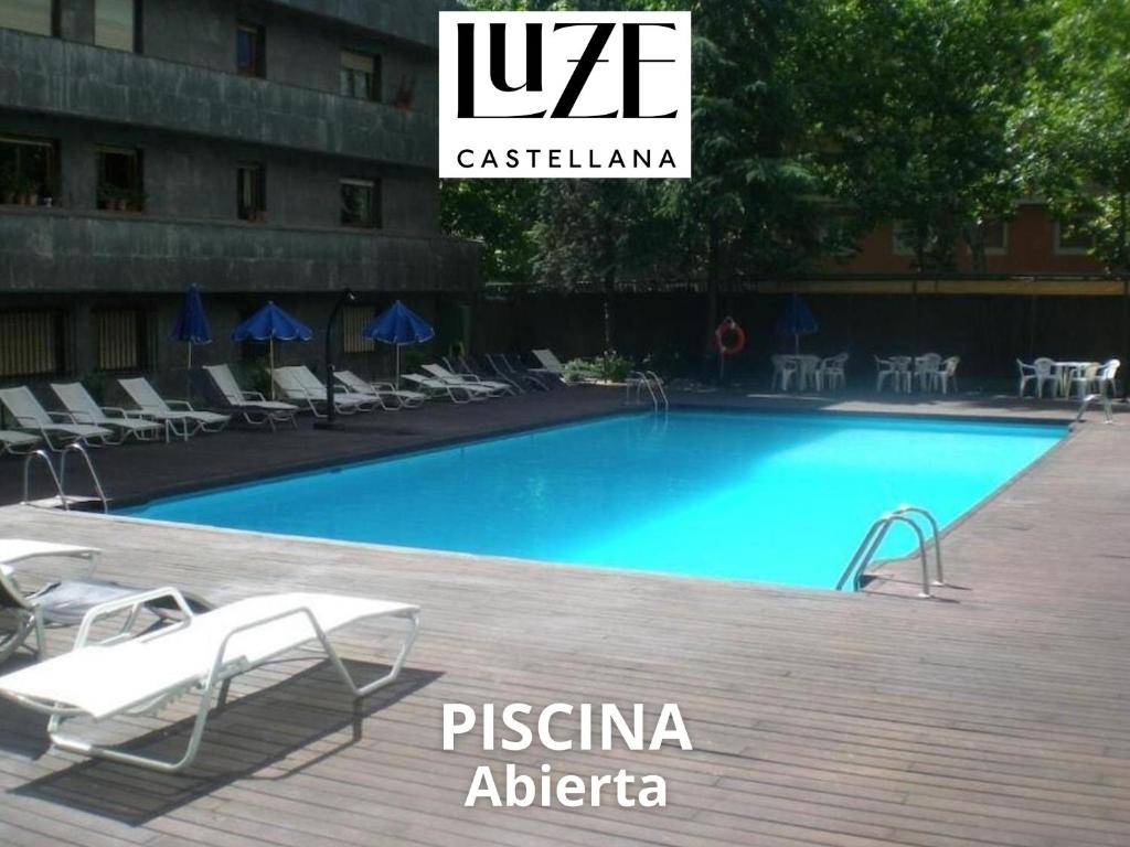 马德里Luze Castellana的一个带椅子和签证标志的大型游泳池