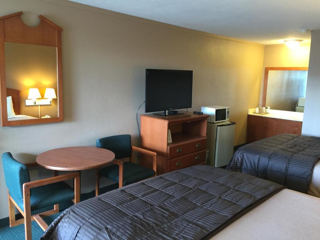 圣罗伯圣罗伯特经济酒店 的一间酒店客房,配有一张床铺、一张桌子和一台电视