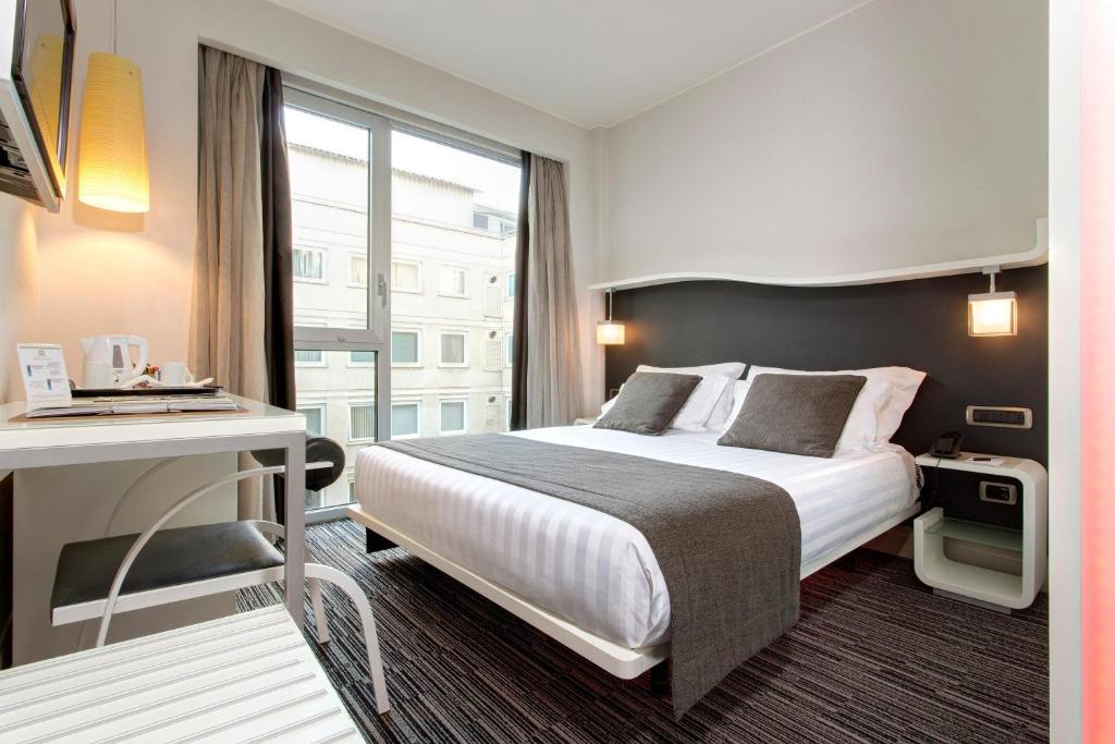 罗马贝斯特韦斯特皇家圣缇纳大酒店的一间设有大床和窗户的酒店客房
