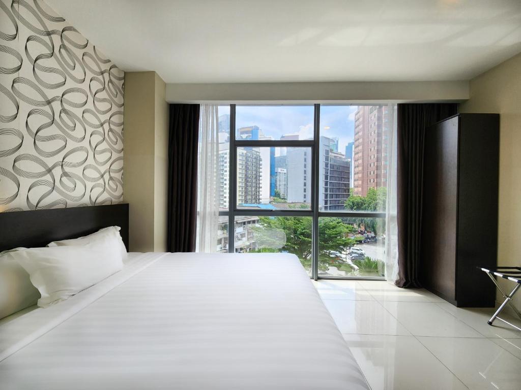 吉隆坡Izumi Hotel Bukit Bintang Kuala Lumpur的一间卧室设有一张大床和大窗户