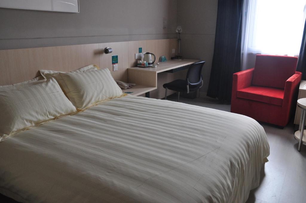 萧山锦江之星萧山国际机场店的酒店客房,配有一张床和一张红色椅子