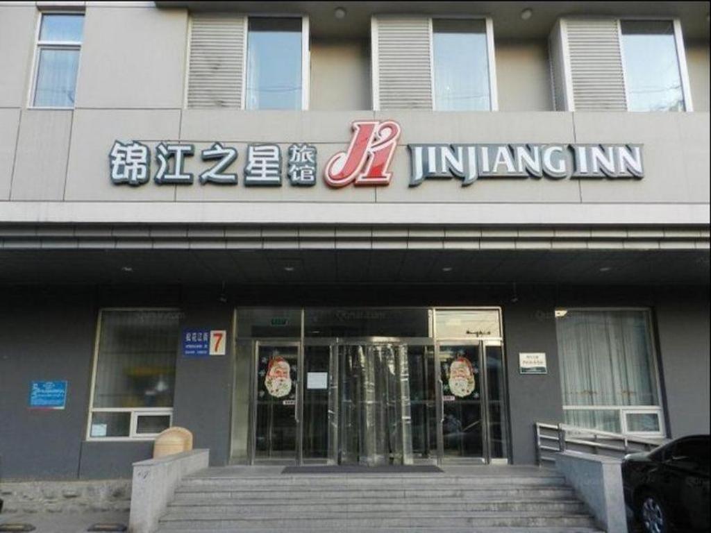 沈阳Jinjiang Inn Shenyang North Station的前面有标志的建筑