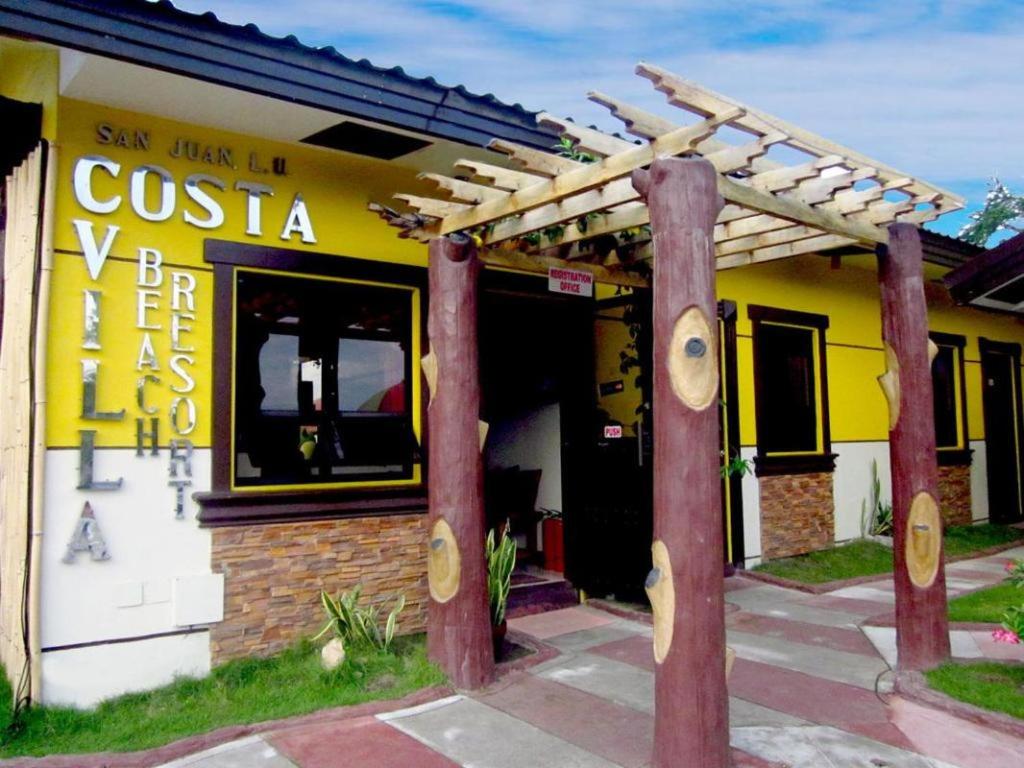 圣胡安Costa Villa Beach Resort的一间设有黄色建筑和凉棚的餐厅