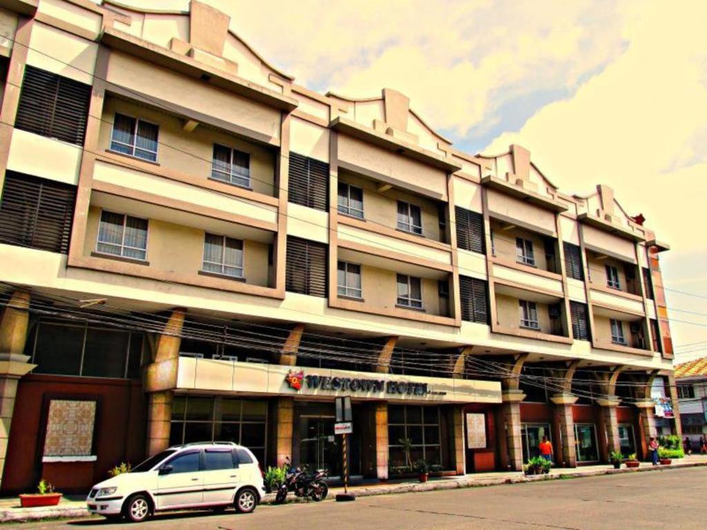 巴科洛德MO2 Westown Hotel San Juan的前面有停车位的建筑