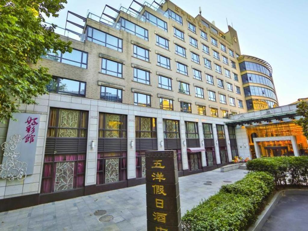 杭州Wuyang Holiday Hotel Hangzhou的前面有标志的大建筑