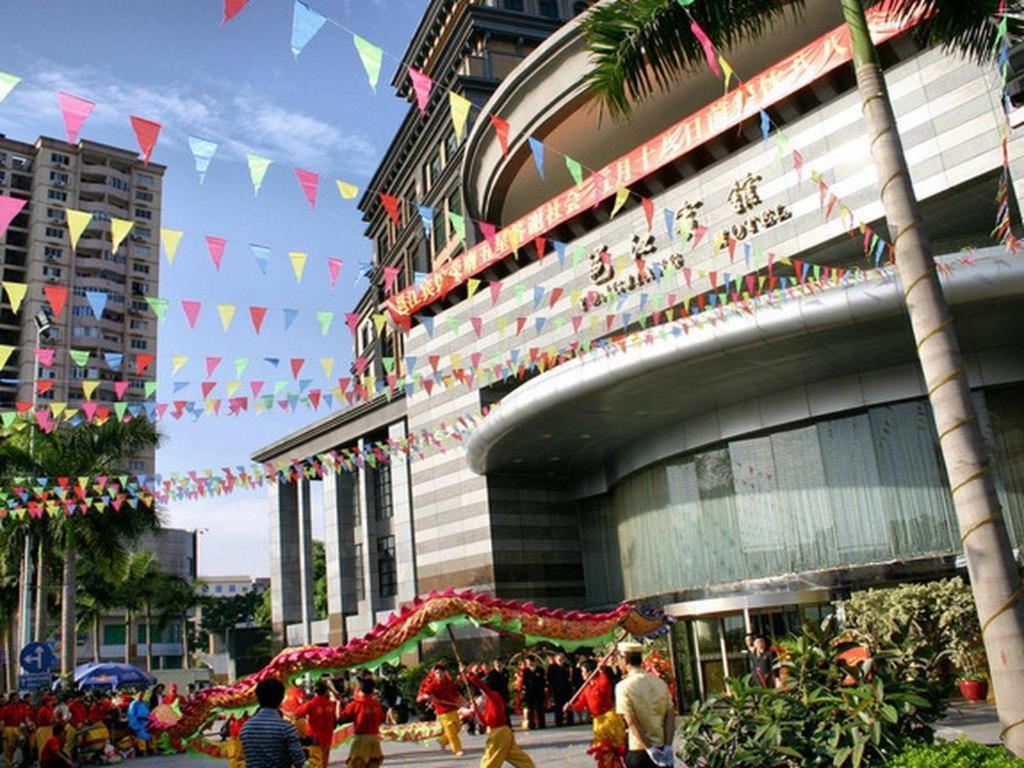 南宁Nanning Yongjiang Hotel的一群人走在一座大楼前