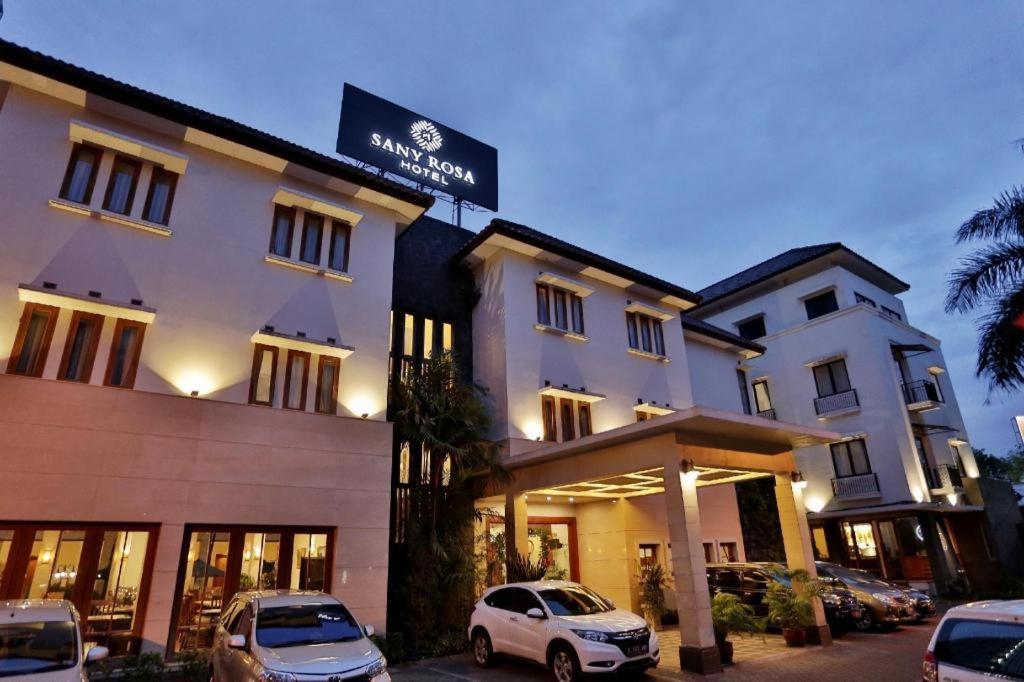 万隆Sany Rosa Hotel的前面有两辆车的酒店