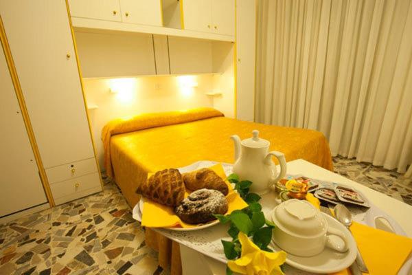 索托马里纳美杜莎酒店的一间房间,配有一张床和一张桌子,上面有食物