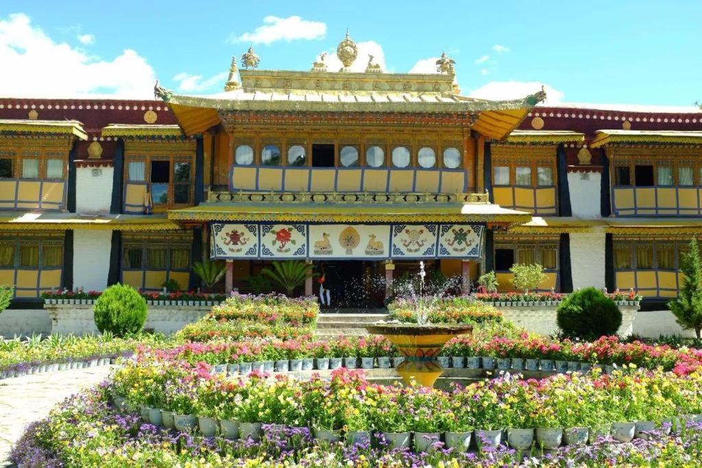 拉萨Lavande Hotels Potala Palace Najin Road的一座大建筑前面有鲜花