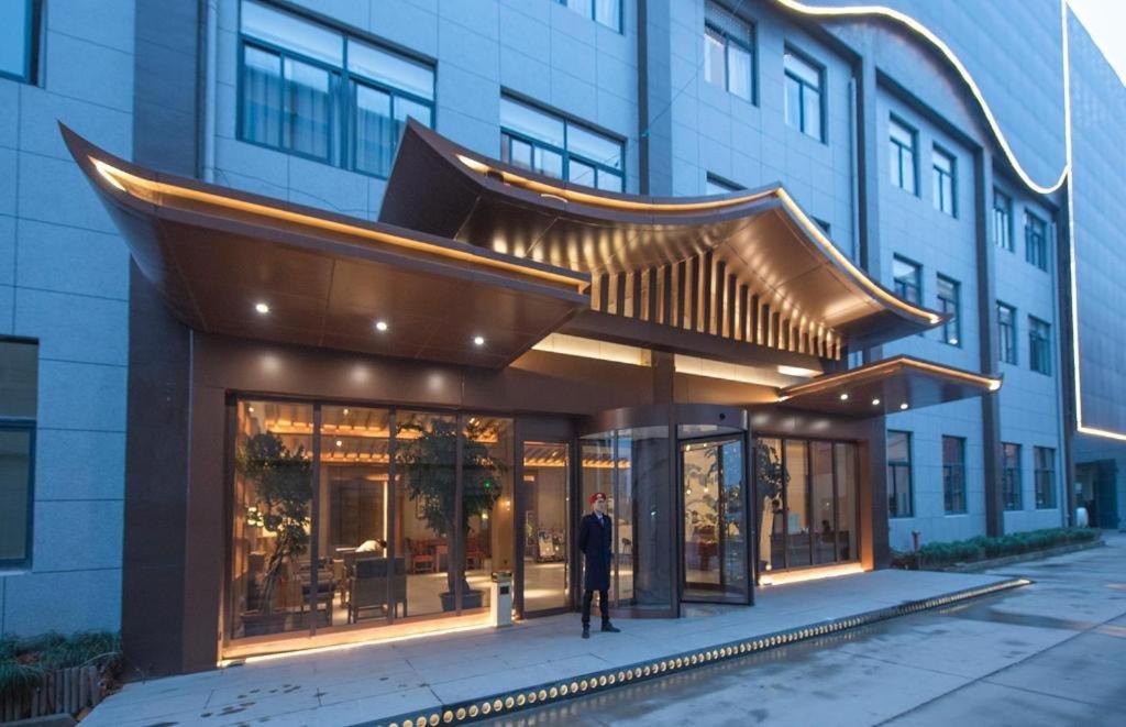 杭州S·dor Hotel Hangzhou Xiaoshan Intertational Airport的一个人站在建筑物前面