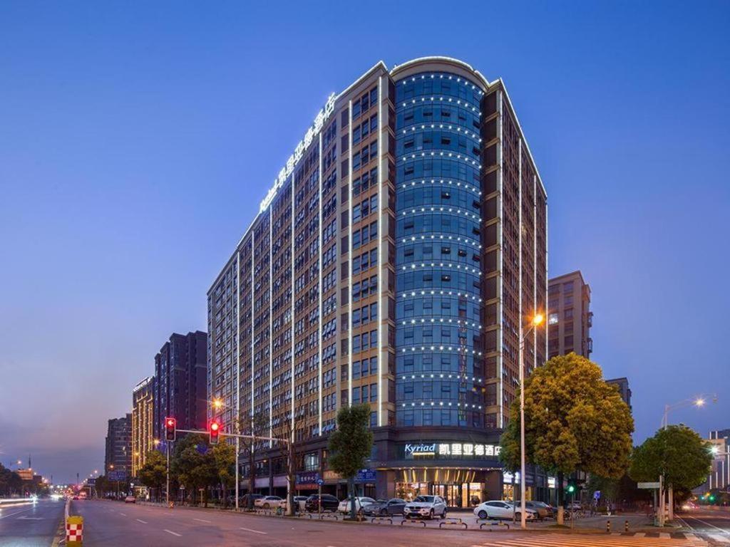 长沙Kyriad Marvelous Hotel Changsha Provincial Government Desiqin的夜幕降临的城市街道上一座高楼