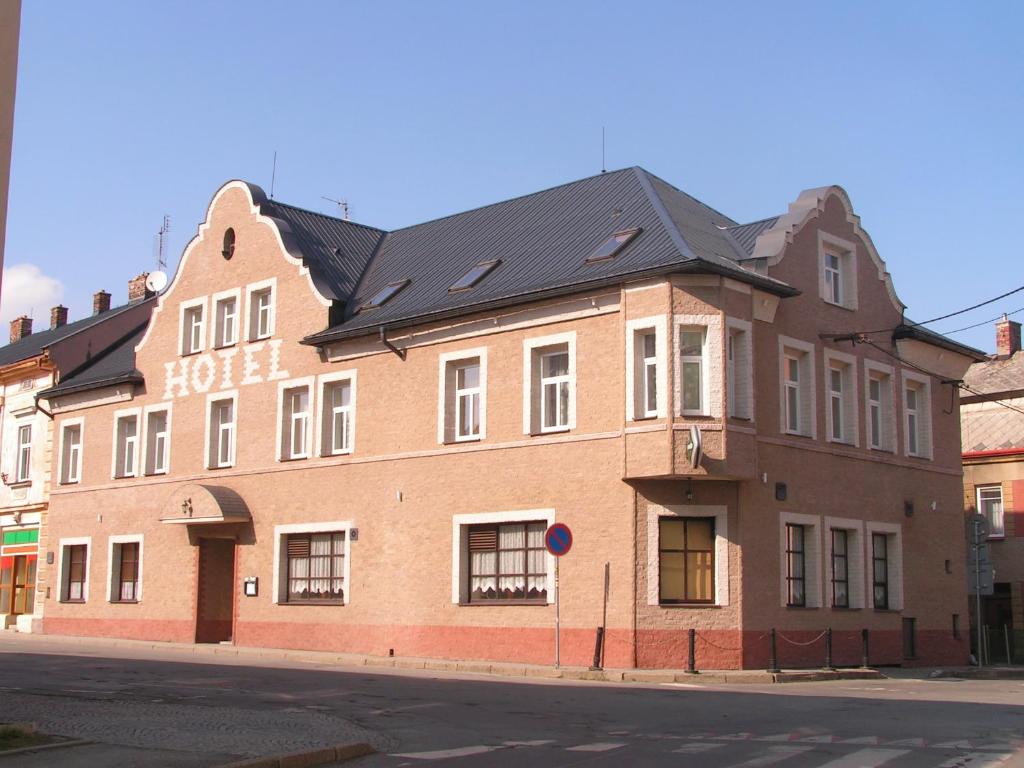 里马若夫Hotel Praděd Rýmařov的街道拐角处的一块大砖砌建筑