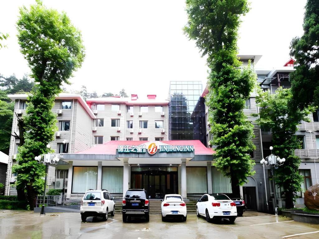 九江Jinjiang Inn select Lushan Scenic Xiangshan Road Yunzhong Hotel的停车场内有车辆的旅馆