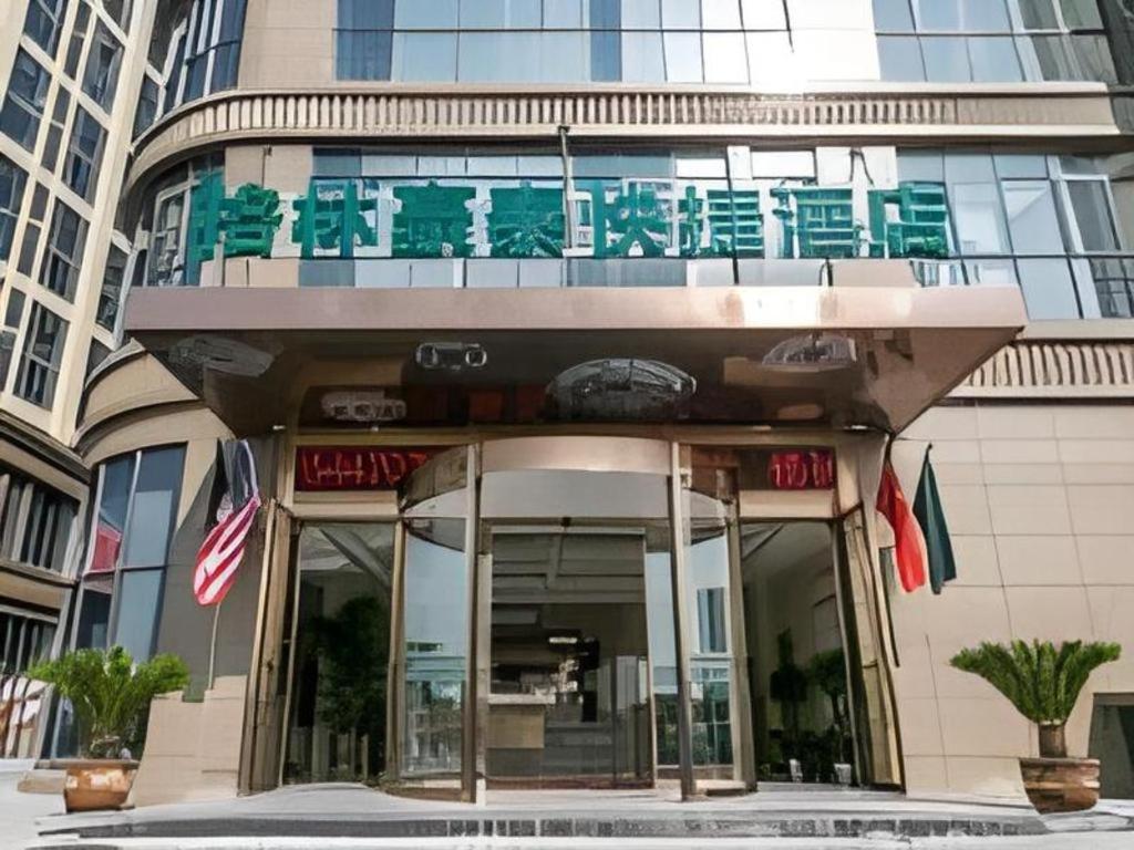 苏州GreenTree Inn Suzhou Wujiang Fenhu Development District的一座建筑的顶部设有绿色椅子