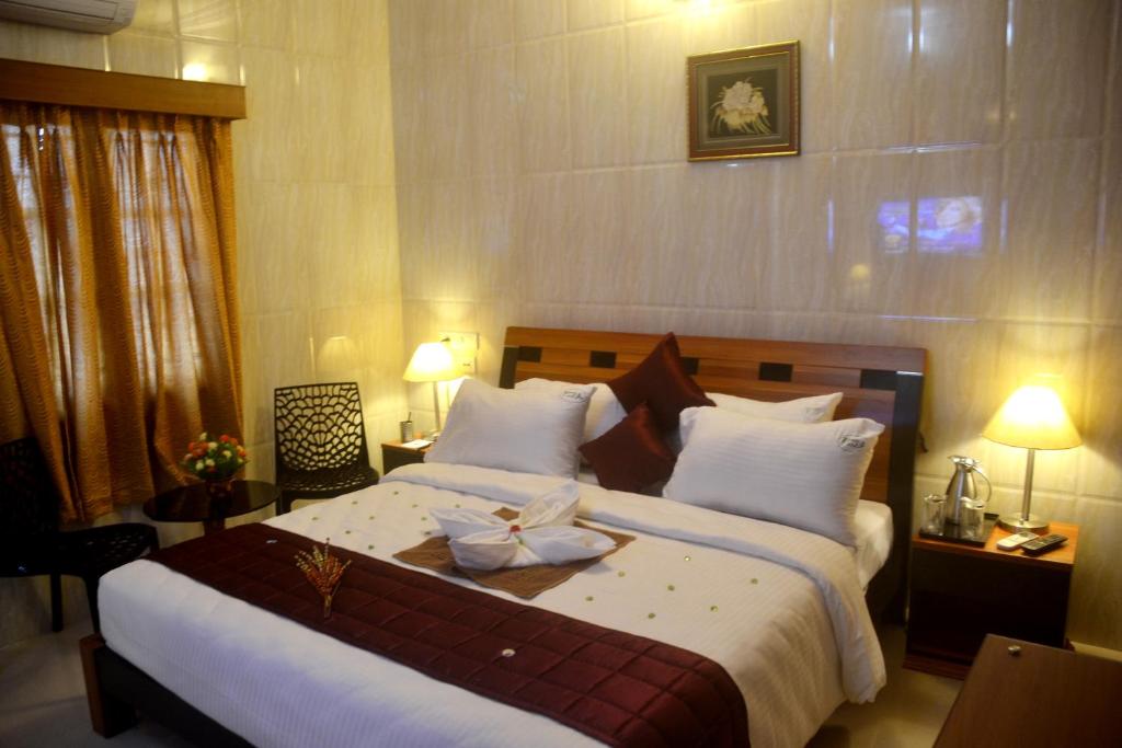 钦奈Peace Inn Chennai的一间卧室配有一张大床,上面有弓