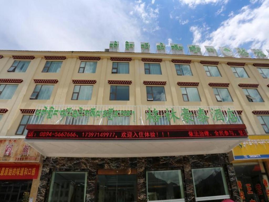 林芝GreenTree Inn Tibet Nyingchi City Biji Shenshan的一座大型棕褐色建筑,上面设有阳台