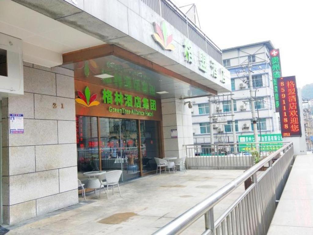 贵阳GreenTree Alliance Hotel Guiyang Huaguo Community Central Business Zone的一座建筑的前面设有餐厅,配有椅子