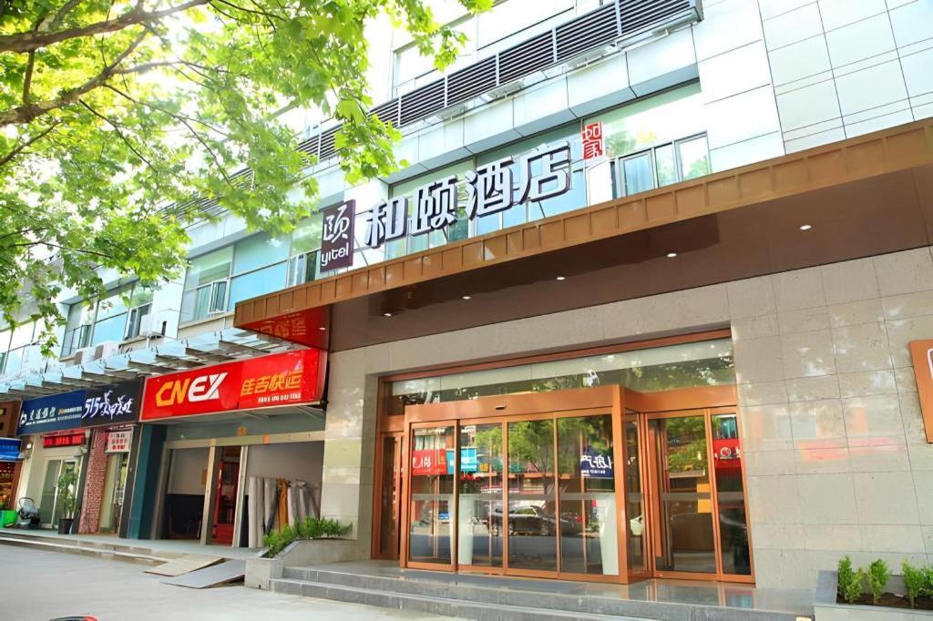 上海Home Inn Plus Shanghai Middle Ring Jinshajiang Road Fengzhuang Metro Station的建筑的侧面有标志