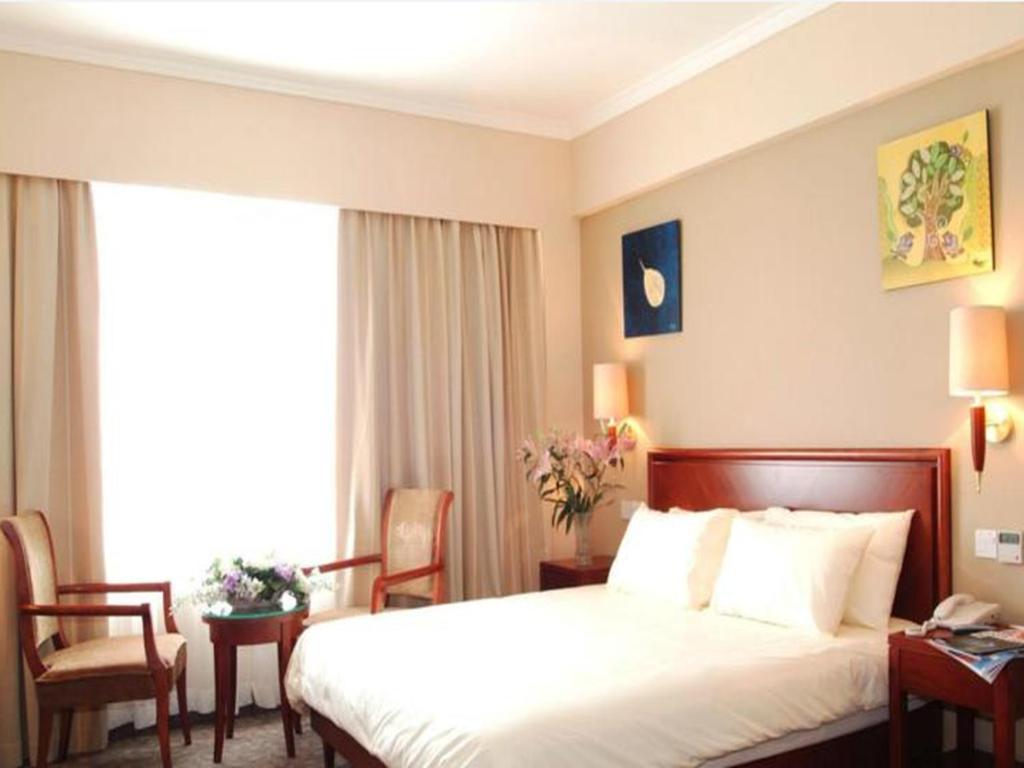 北京GreenTree Inn Beijing Daxing Xingye Street Liyuan Business Hotel的酒店客房带床、椅子和窗户