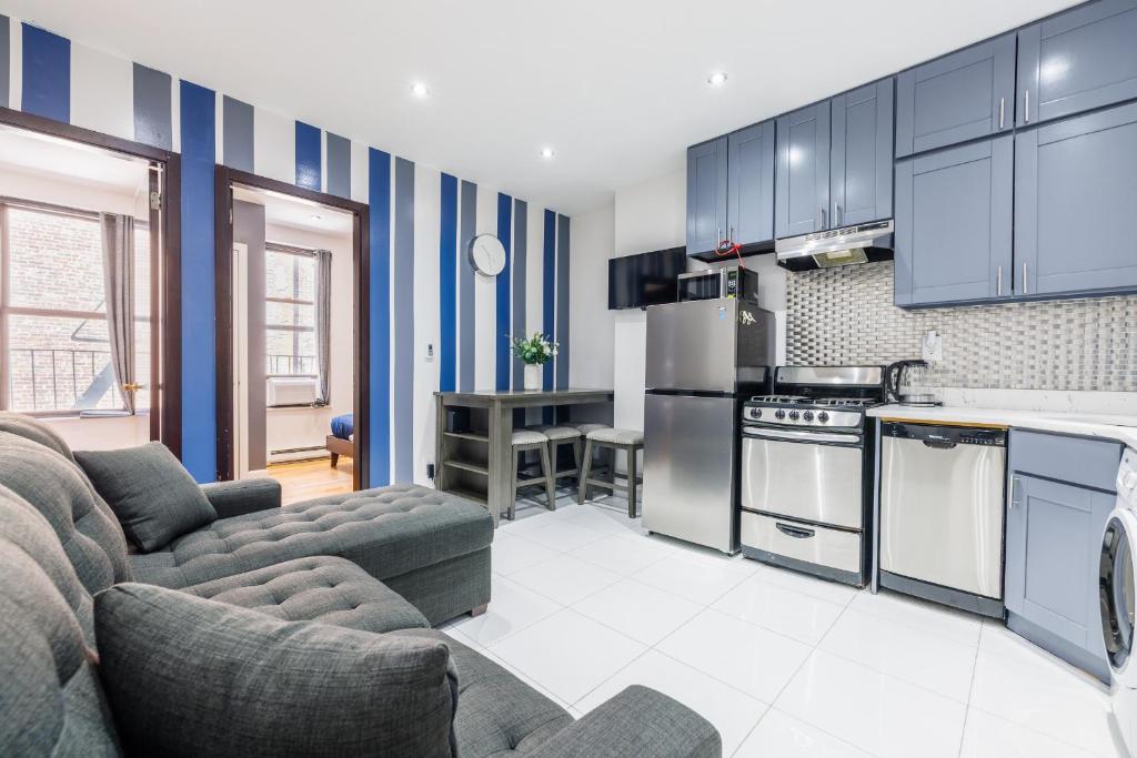 纽约Discover the Comfort of Columbia University Area的厨房以及带蓝色橱柜的客厅。