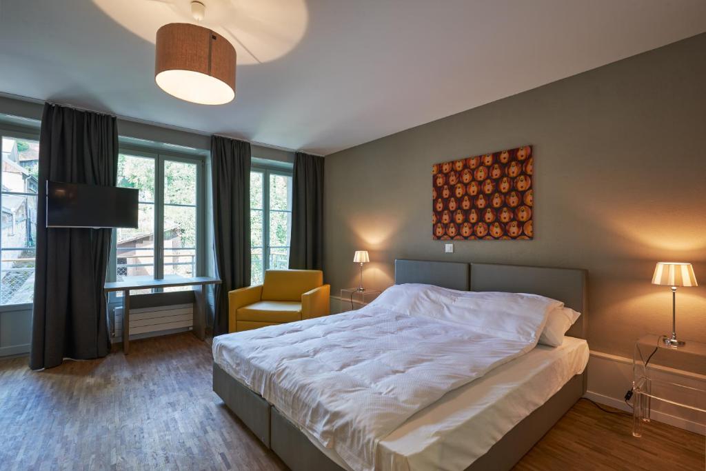 弗里堡Hotel Hine Adon Fribourg的一间卧室配有一张床、一把椅子和窗户。