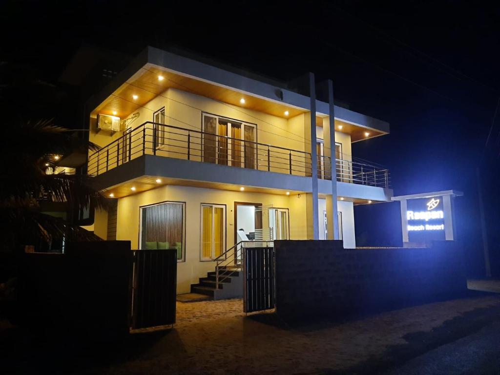 马尔万Raapan Beach Resort的夜晚点亮的房屋,灯火在里面
