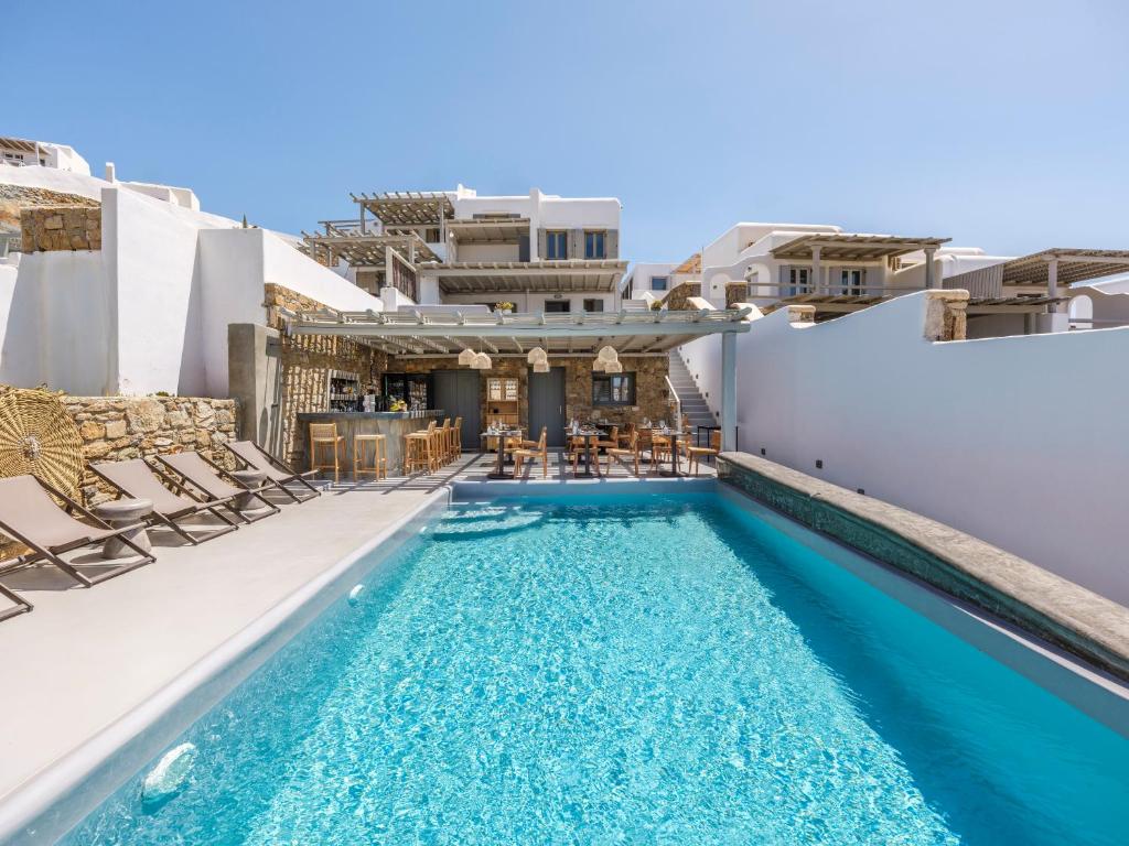 Merchia BeachSea Rock & Sky Private Mykonos Residence的一座带椅子的游泳池以及一座建筑