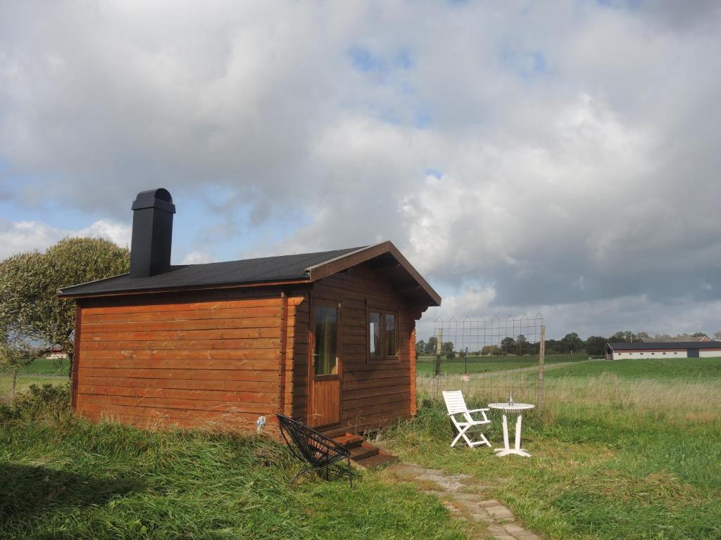 LövestadBhumi's farm的小屋配有桌子和椅子