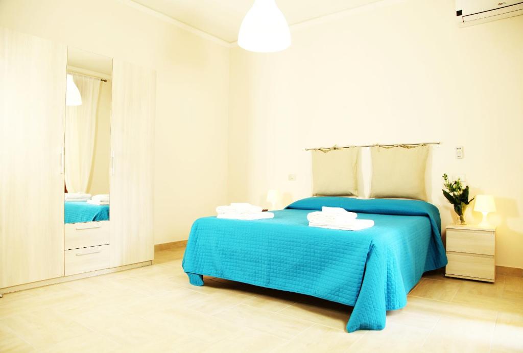 里波斯托Casa A Riba U Mari的白色卧室配有蓝色的床和镜子