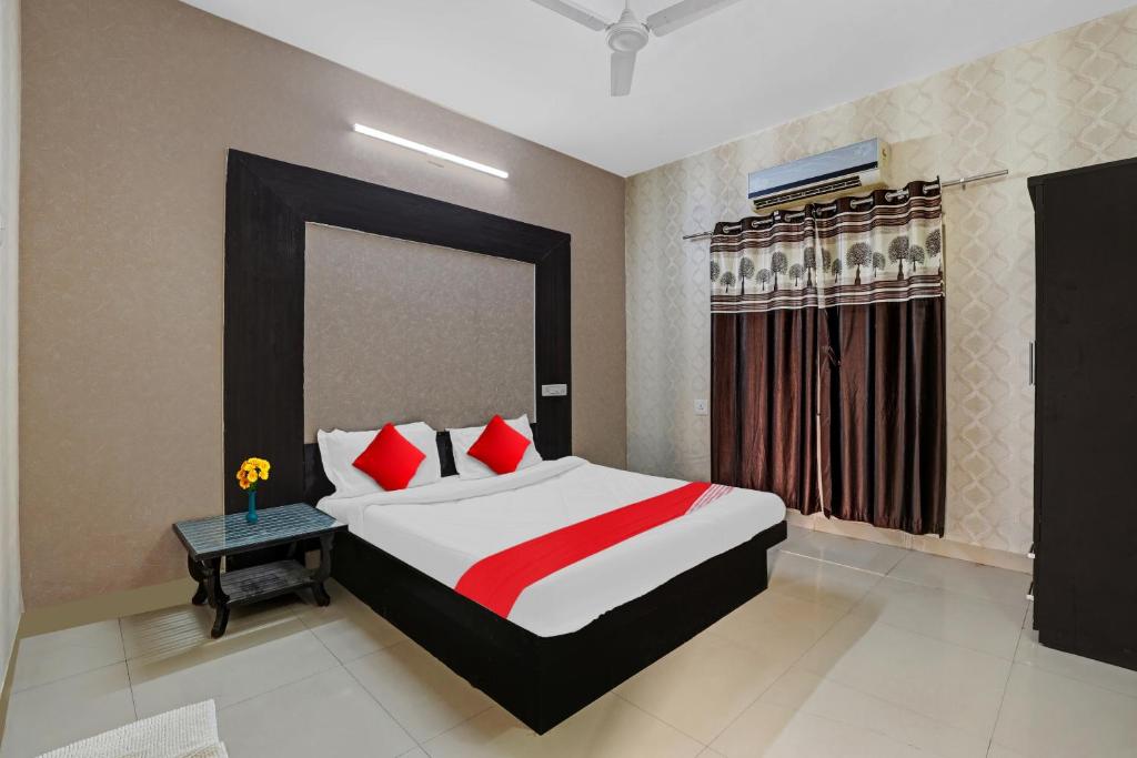 艾哈迈达巴德OYO Hotel Sargam的一间卧室配有红色和白色枕头的床