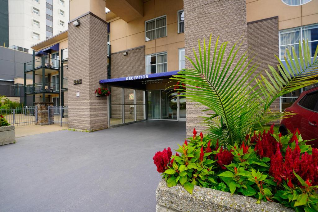 魁北克市Hôtel Lindbergh par JARO的一座建筑,前方有种鲜花的庭院