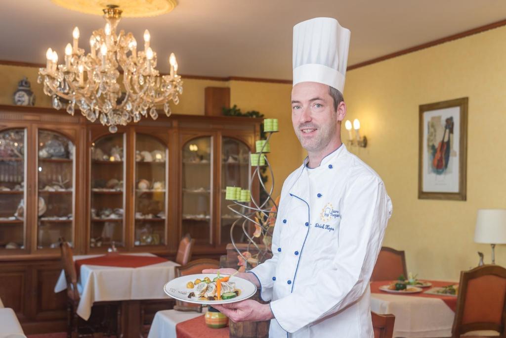 梅尔施卢森堡大公国之家的餐厅的厨师,持着一盘食物