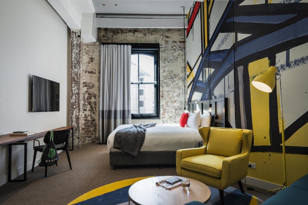 悉尼The Woolstore 1888的酒店客房,配有床和黄色椅子