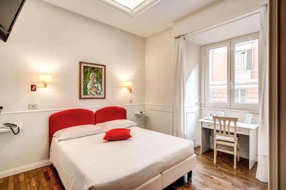 罗马B&B Hotel Roma Italia Viminale的一间卧室配有一张带红色床头板的床和一张书桌