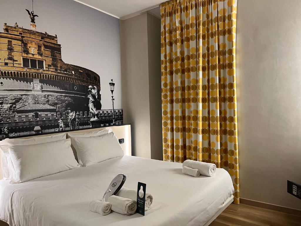 罗马B&B Hotel Roma San Lorenzo Termini的一间卧室配有一张床,上面有两条毛巾