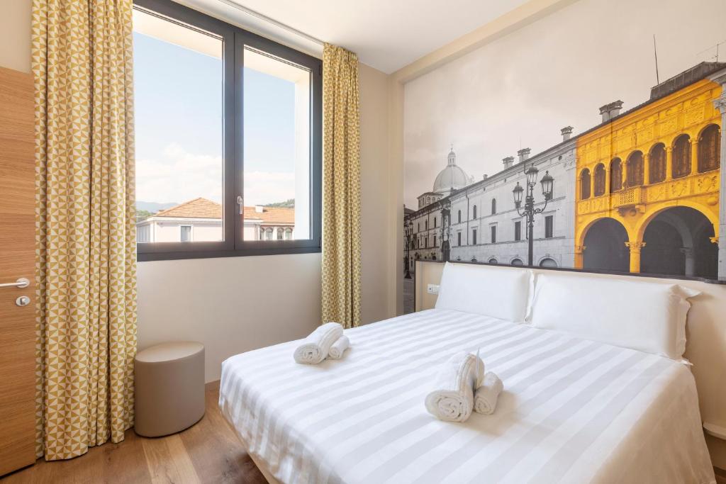 布雷西亚B&B Hotel Brescia的卧室配有白色床和2条毛巾