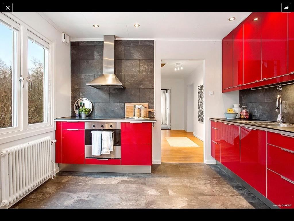 Härryda兰德维特民宿的一间厨房,配有红色橱柜和大窗户