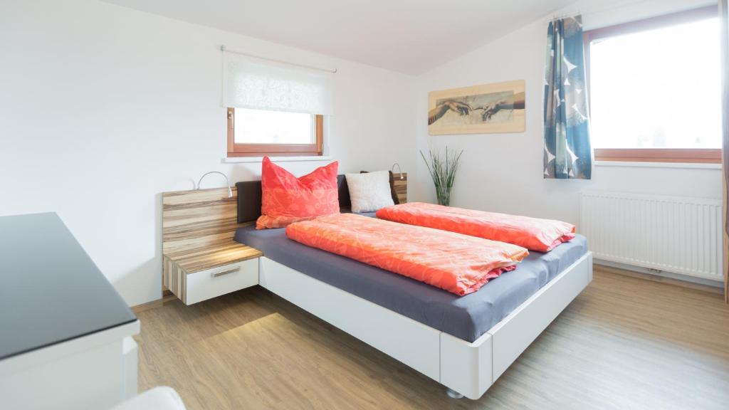 利恩茨Merlin的一间卧室配有带橙色枕头的床