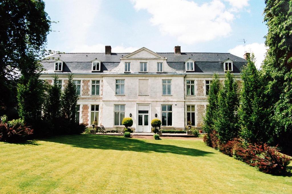 赫恩Chambres d'hôtes Château de Courcelette的一座大型白色房子,设有大院子