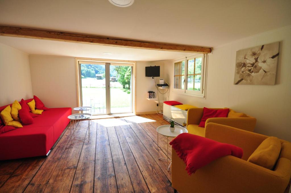 施特歇尔贝格瀑布木屋的客厅设有红色和黄色的沙发,铺有木地板。