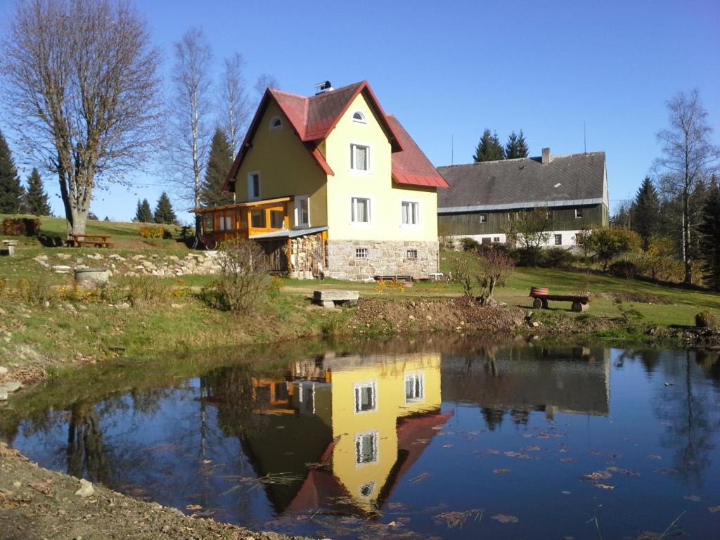 PerninkChata Rybná 18的前面有池塘的房子