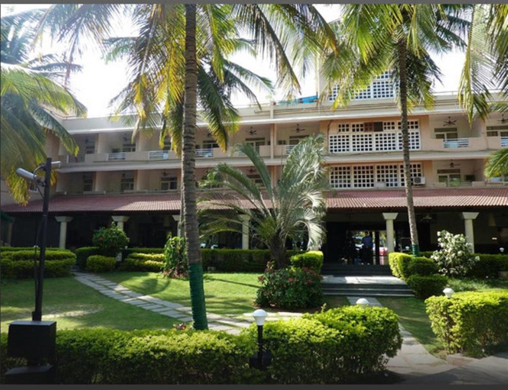 班加罗尔Royal Orchid Resort & Convention Centre, Yelahanka Bangalore的一座棕榈树环绕的大建筑