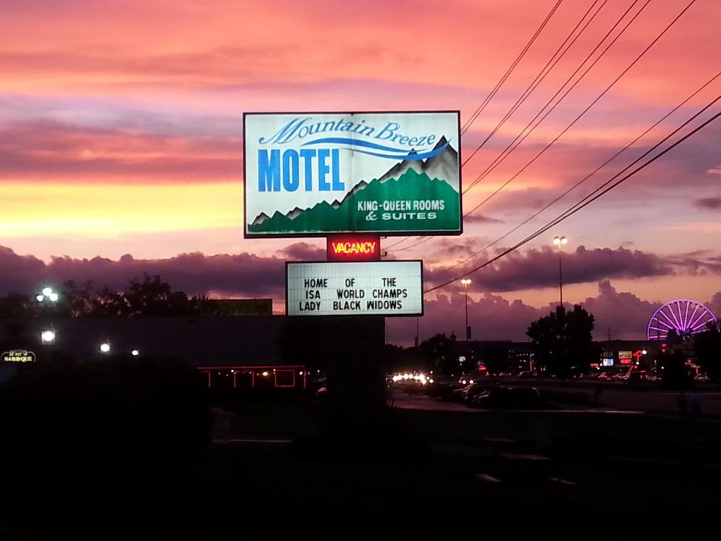 鸽子谷山风汽车旅馆 的一条有日落的道路边的汽车旅馆标志