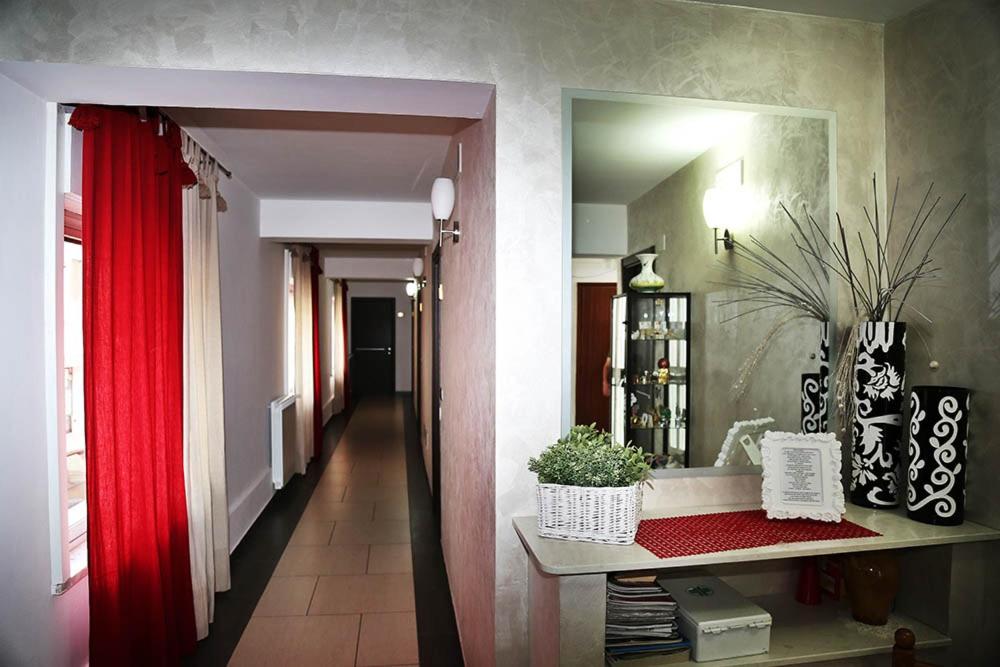 甘吉米拉蒙蒂酒店的一间设有红色窗帘和走廊的房间