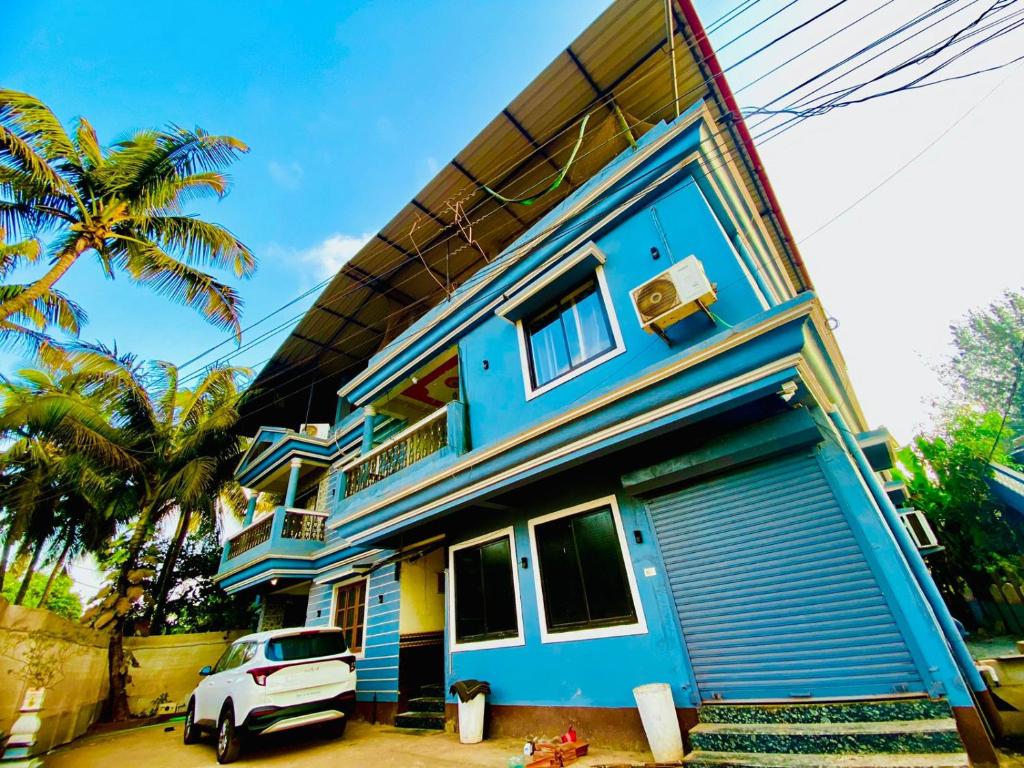 莫尔吉姆Vyana villa rooms的蓝色的房子,前面有停车位