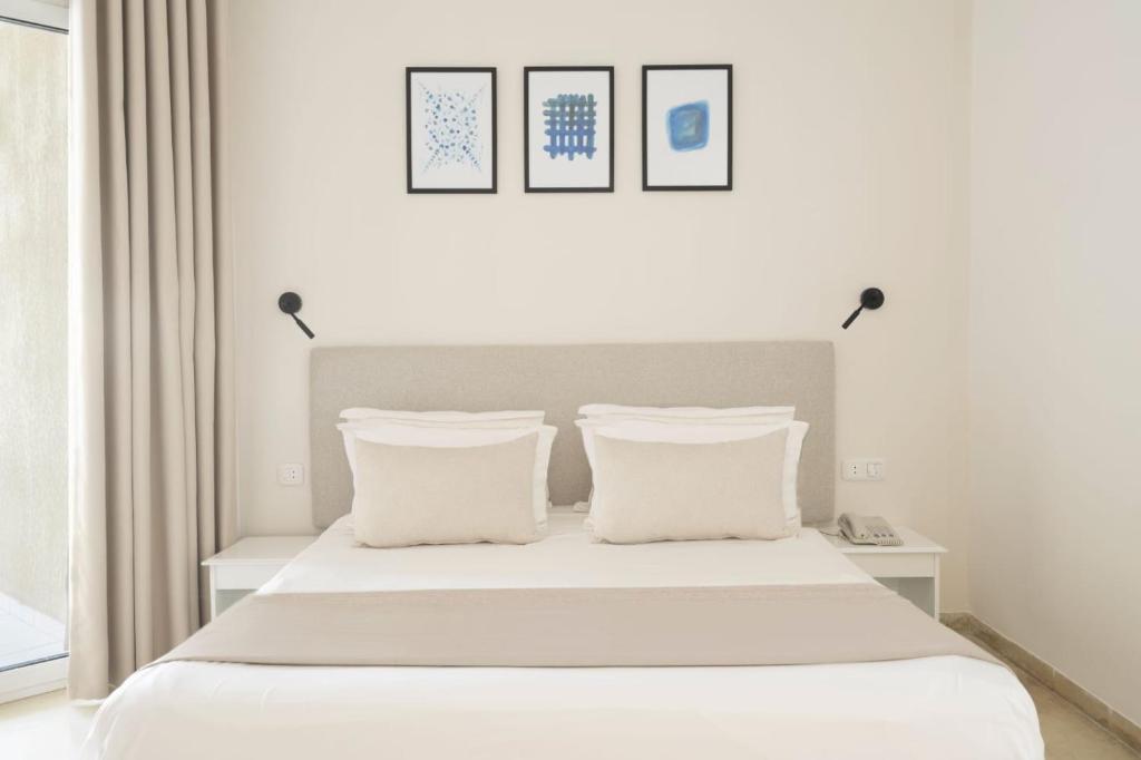 哈马马特Houda Yasmine Marina & SPA的卧室配有白色床和2个白色枕头
